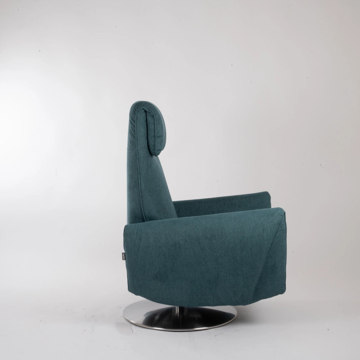 Dreh-Relaxsessel Muna von egoista in petrolfarbenem Stoffbezug, frontal aufgenommen mit ergonomischer Rückenlehne, weicher Polsterung und drehbarem Metallfuß – ein stilvoller und komfortabler Sessel für entspanntes Sitzen seitliche Ansicht.
