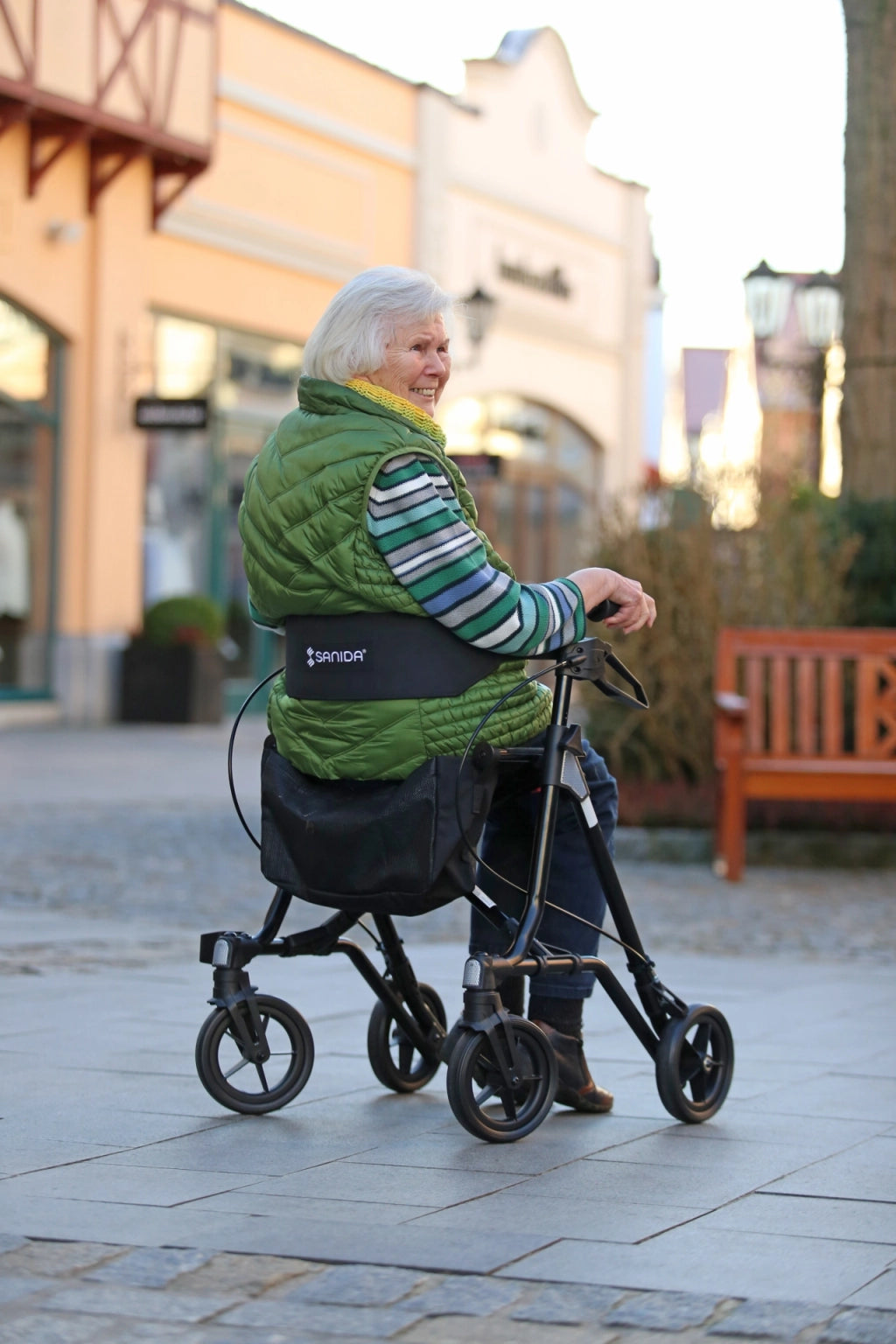 Alte Frau sitzend auf dem Sanida Rollator in einer Einkaufspassage
