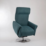 Dreh-Relaxsessel Muna von egoista in petrolfarbenem Stoffbezug, schräg seitlich aufgenommen mit sichtbarem motorisierten Mechanismus und drehbarem Metallfuß – eleganter und komfortabler Sessel für entspanntes Sitzen.